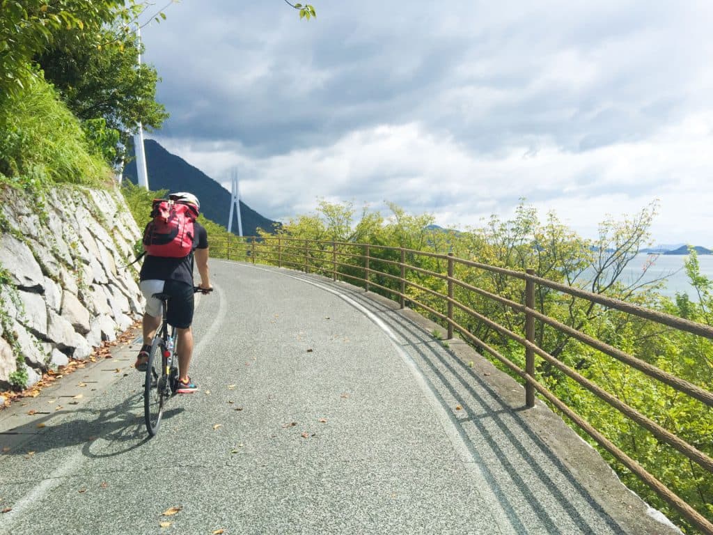 坂道をロードバイクで上る男性
