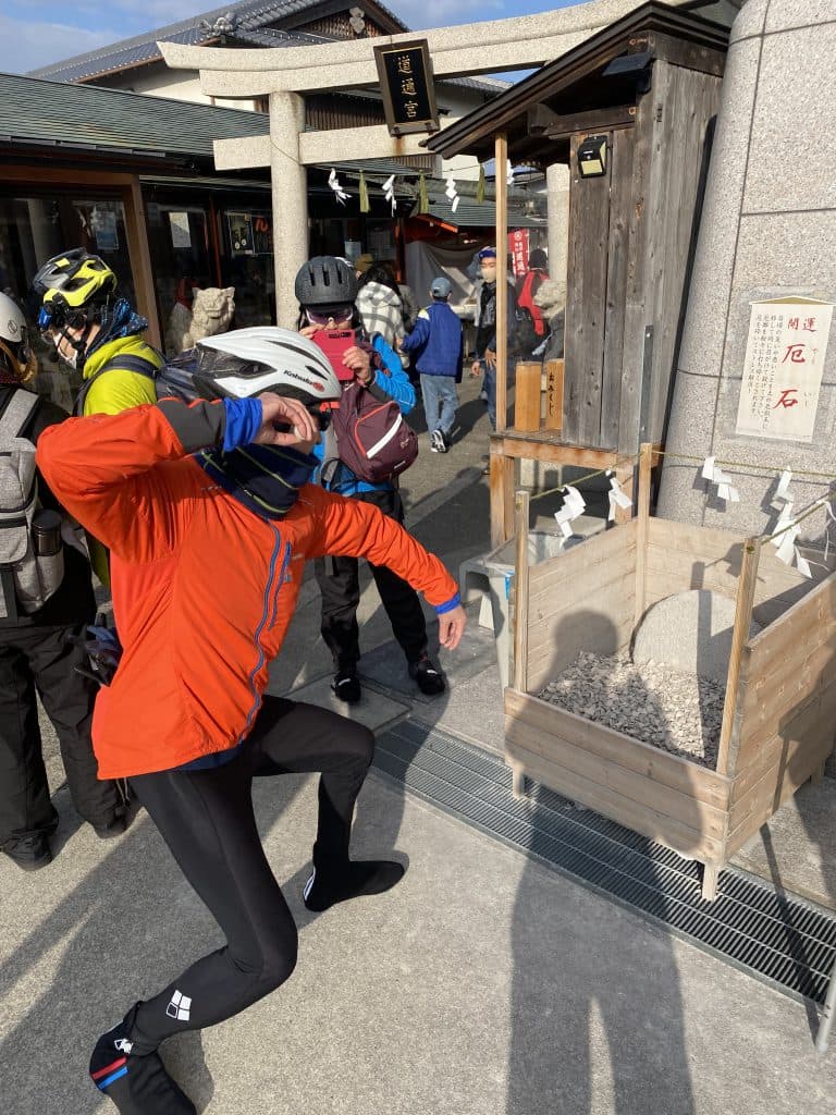 開運厄石に向かって石を投げる参加者